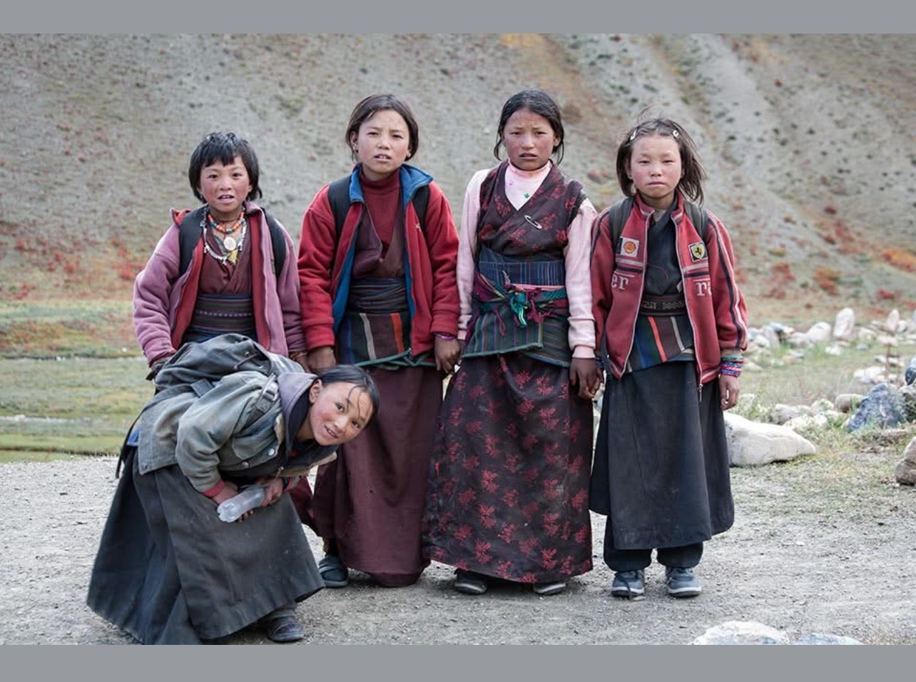 Five children in Tsum Valley wearing traditional Tibetan-style clothing.